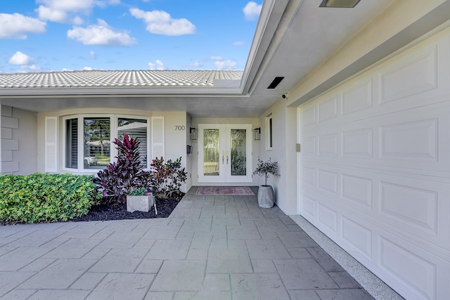 entrance to property with a garage and french doors