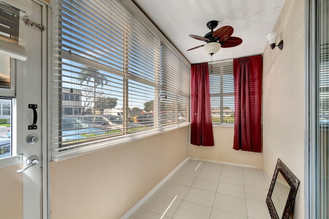 unfurnished sunroom with ceiling fan