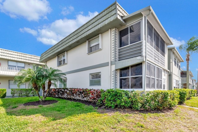 view of property exterior with a lawn and stucco siding