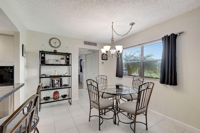 dining area with light tile patterned floors, baseboards, visible vents, and an inviting chandelier