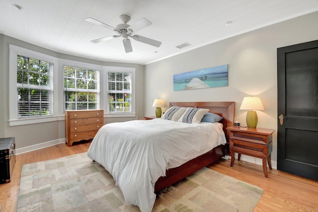 bedroom featuring visible vents, ceiling fan, light wood-style flooring, and baseboards