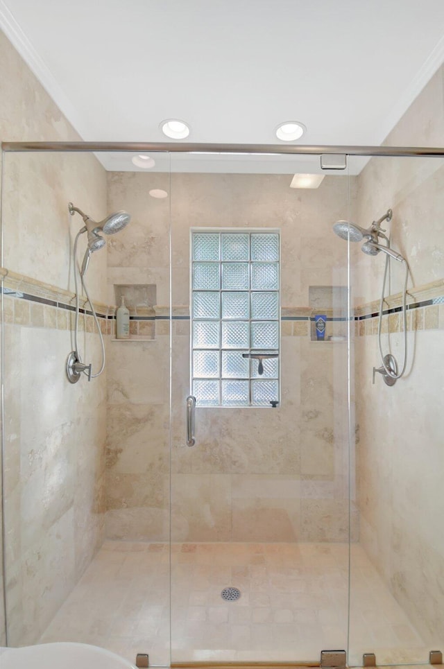 full bath featuring ornamental molding and a shower stall