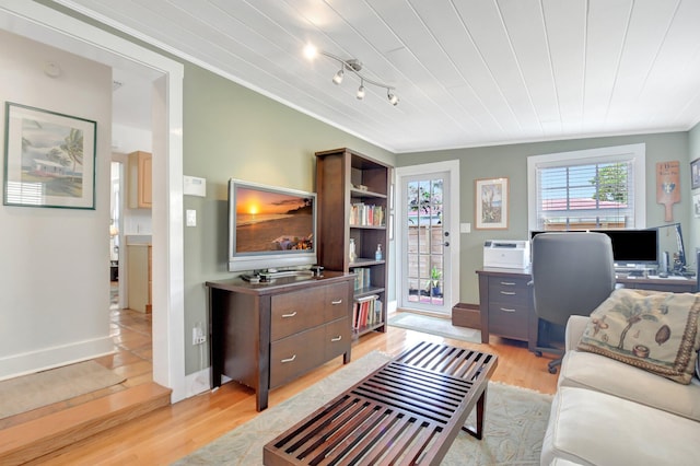 living area featuring light wood-style flooring, baseboards, and crown molding