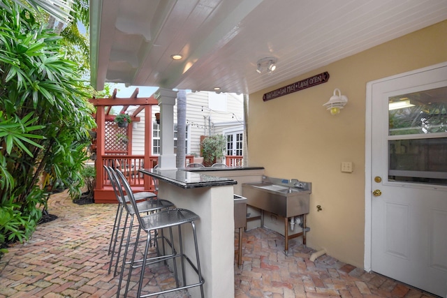 view of patio with outdoor wet bar and area for grilling