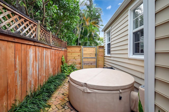 view of patio / terrace with fence and a hot tub