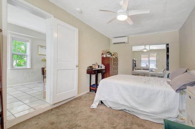 bedroom featuring a ceiling fan, a wall mounted air conditioner, light carpet, and baseboards