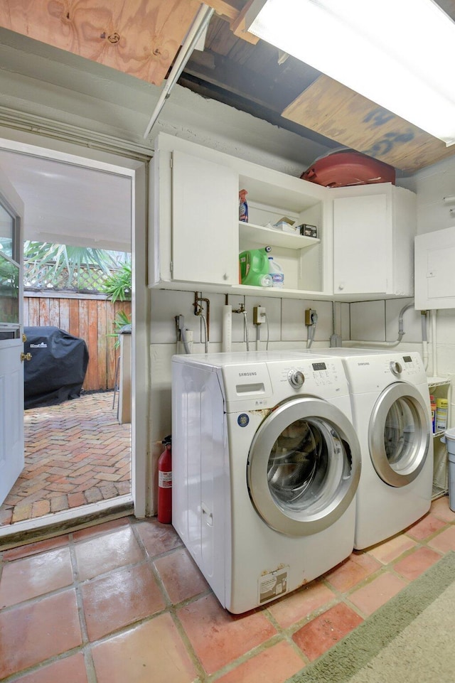 clothes washing area with cabinet space and separate washer and dryer