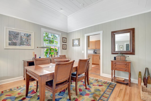 dining space with crown molding, light wood-type flooring, and baseboards