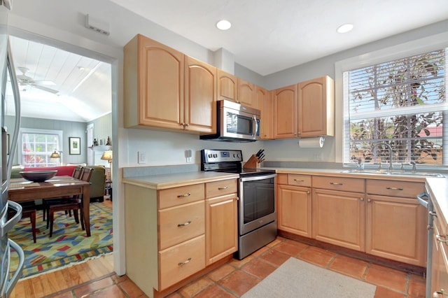 kitchen featuring light countertops, light brown cabinetry, a sink, and stainless steel appliances