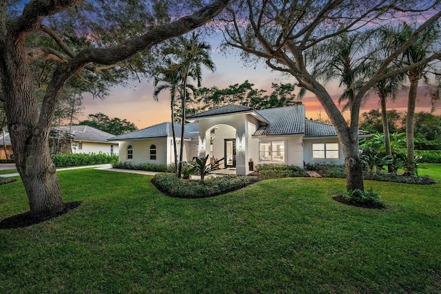 mediterranean / spanish home featuring a lawn