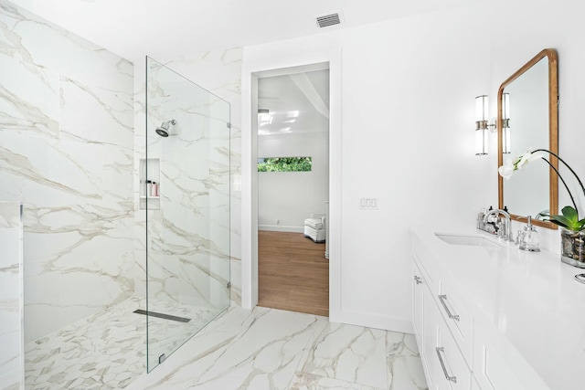 bathroom featuring tiled shower and vanity