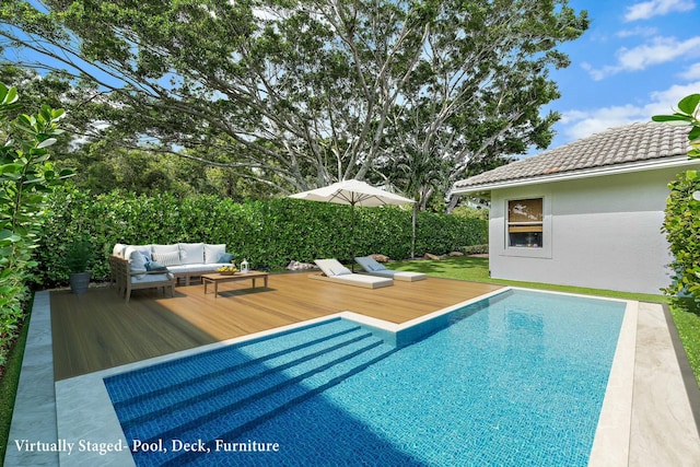 view of pool with outdoor lounge area and a deck