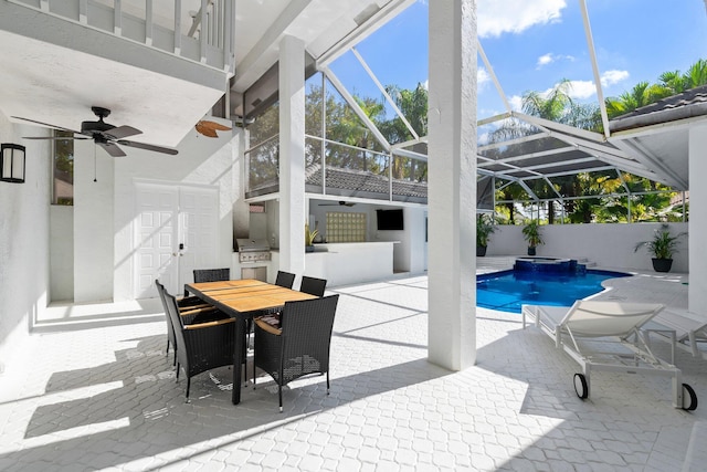 view of pool with a lanai, an outdoor bar, ceiling fan, a patio, and exterior kitchen