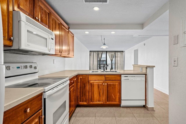 kitchen with light tile patterned flooring, sink, white appliances, kitchen peninsula, and a textured ceiling