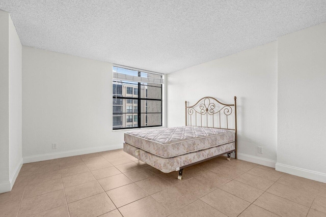 tiled bedroom featuring a textured ceiling