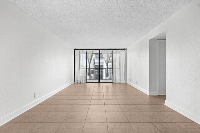 unfurnished room with a textured ceiling and light tile patterned floors