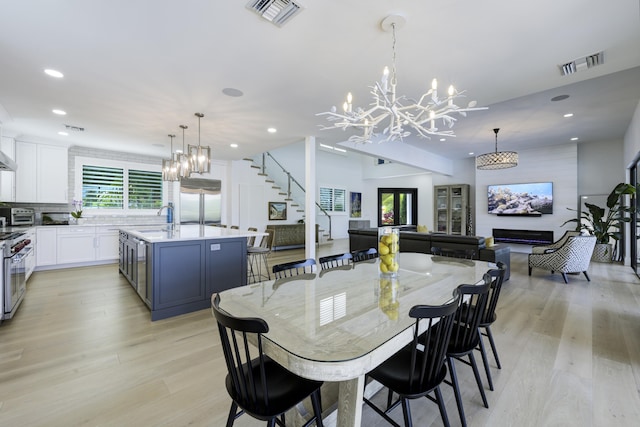 dining area with light wood-type flooring, stairway, visible vents, and recessed lighting