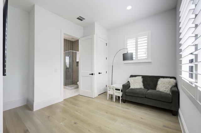 living area featuring light wood-style flooring, recessed lighting, visible vents, and baseboards