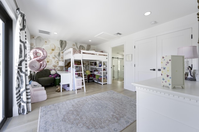 bedroom featuring light wood-style flooring, ensuite bath, visible vents, and recessed lighting