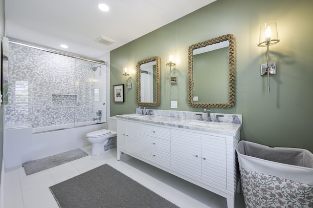 bathroom with shower / bath combination with glass door, double vanity, visible vents, toilet, and a sink