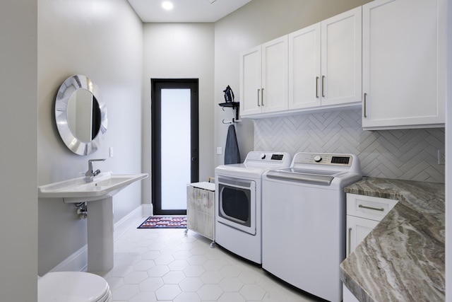 laundry room featuring washing machine and dryer, laundry area, baseboards, and light tile patterned floors