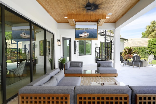 view of patio featuring outdoor lounge area, ceiling fan, and stairs