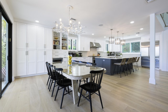 dining room featuring light wood finished floors, a wealth of natural light, and an inviting chandelier