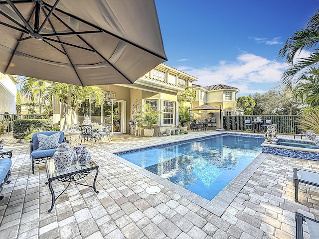 view of swimming pool with an in ground hot tub and a patio area