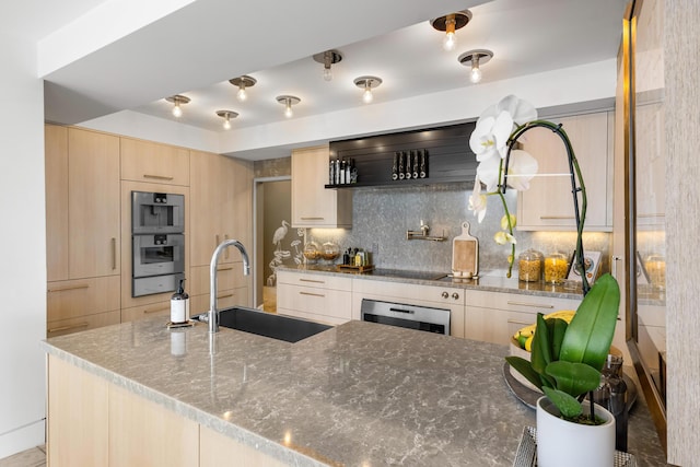 kitchen with light stone countertops, light brown cabinets, and a sink