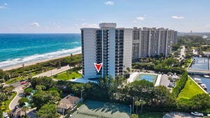 drone / aerial view featuring a water view and a view of the beach