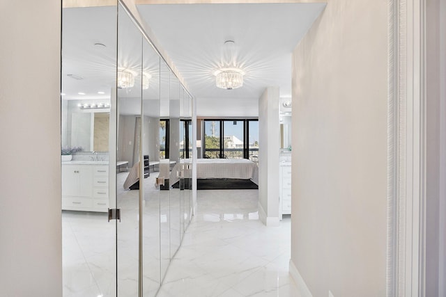 4545 N Ocean Blvd Unit 3A, Boca Raton, FL 33431 - corridor with light marble finish flooring, a chandelier, and baseboards