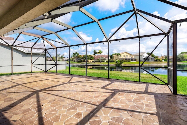 view of patio featuring a water view and a lanai