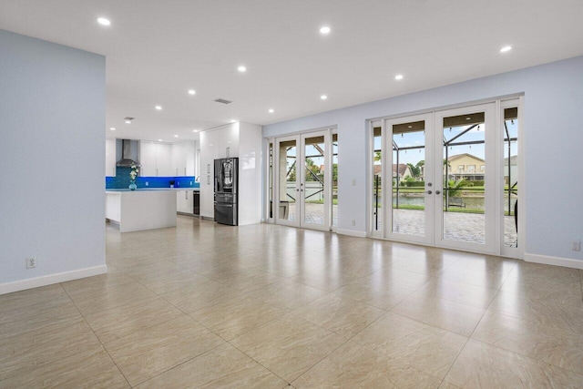 unfurnished living room featuring baseboards, french doors, visible vents, and recessed lighting