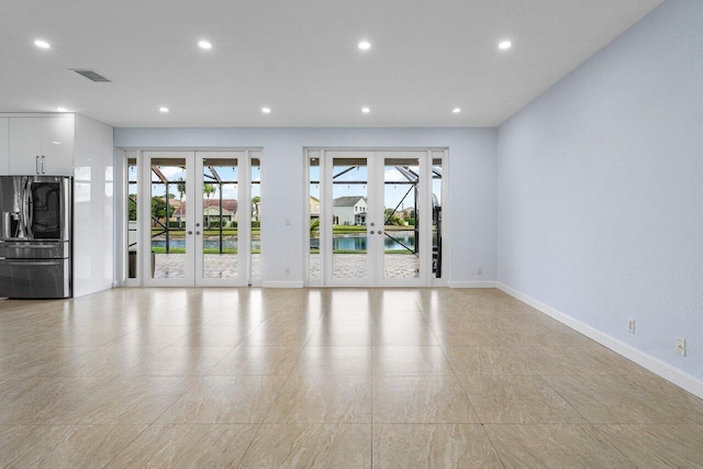 unfurnished living room featuring recessed lighting, visible vents, baseboards, and french doors