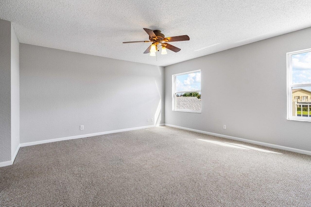 carpeted spare room featuring ceiling fan, a textured ceiling, and baseboards