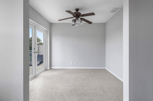 empty room featuring french doors, light colored carpet, visible vents, a textured ceiling, and baseboards