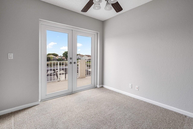 carpeted empty room with a textured ceiling, french doors, a ceiling fan, and baseboards