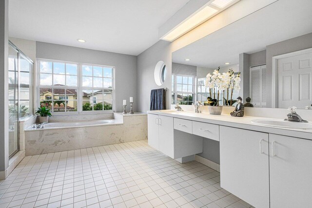 bathroom with a sink, a closet, a bath, tile patterned floors, and double vanity