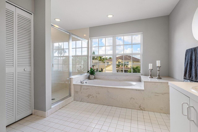 bathroom with a garden tub, a closet, a shower stall, vanity, and tile patterned flooring