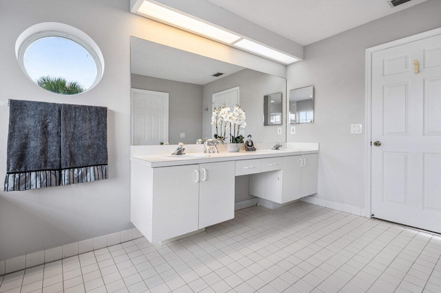 full bath with a sink, visible vents, baseboards, tile patterned floors, and double vanity