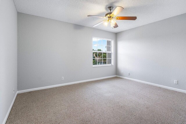 spare room featuring a ceiling fan, carpet, a textured ceiling, and baseboards