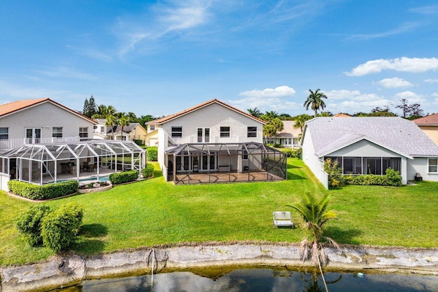 back of house with an outdoor pool, a lanai, a water view, and a lawn