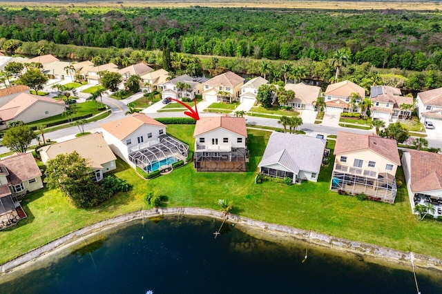 birds eye view of property with a water view, a residential view, and a view of trees