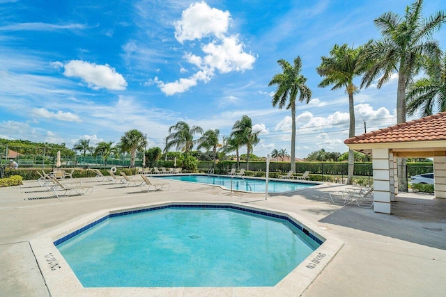 community pool featuring a patio and fence