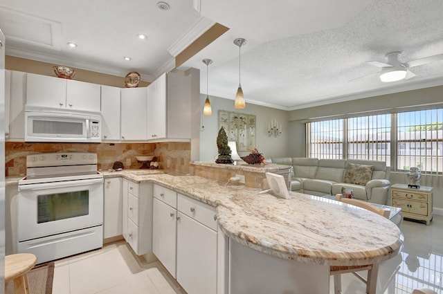 kitchen featuring white cabinetry, a breakfast bar area, white appliances, and kitchen peninsula