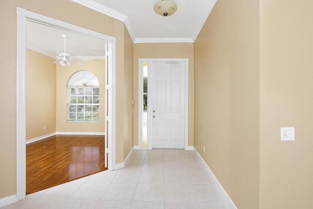 entryway with ceiling fan, ornamental molding, and light tile patterned floors