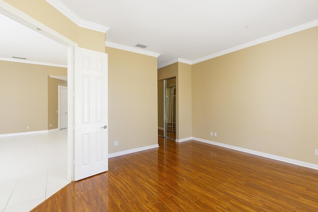 spare room with ornamental molding and wood-type flooring