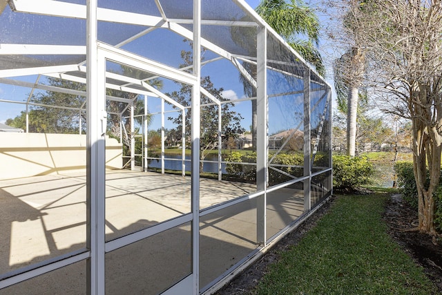 exterior space with a water view and glass enclosure