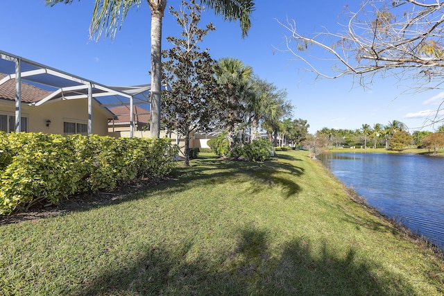 view of yard with a water view and a lanai