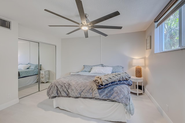 bedroom with light carpet, a closet, a textured ceiling, and visible vents